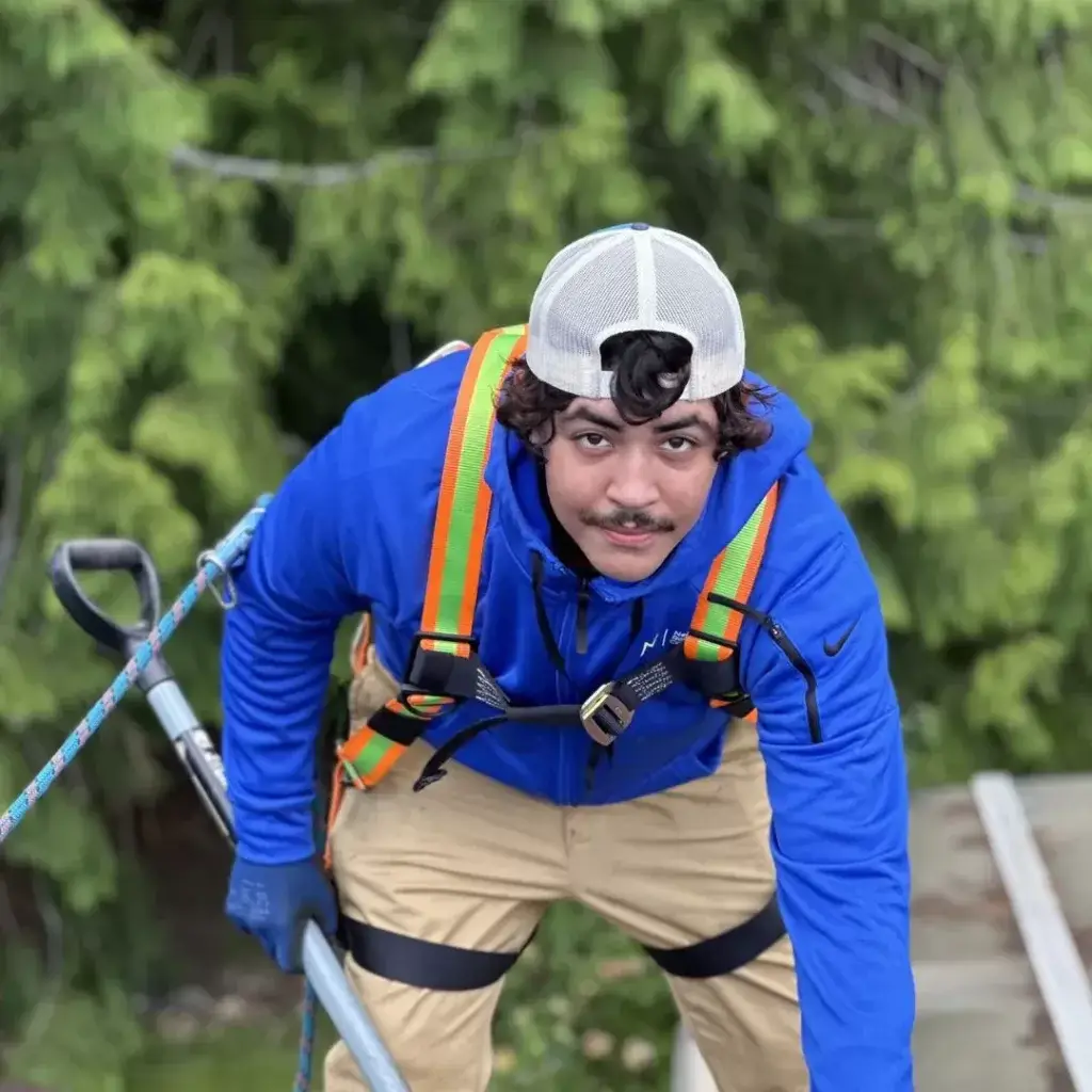 Roofer with safety rope inspecting a roof