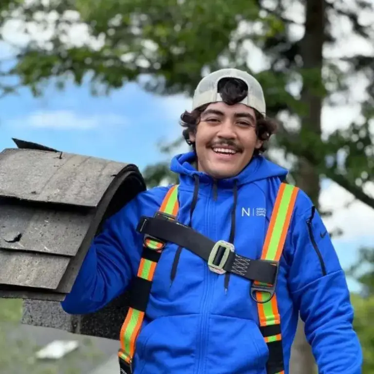Smiling NearMe Roofing technician on a roof