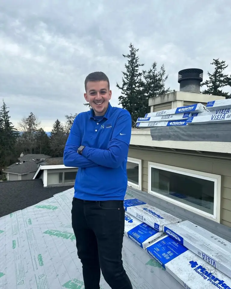 expert male roofer with folded arms standing on the roof