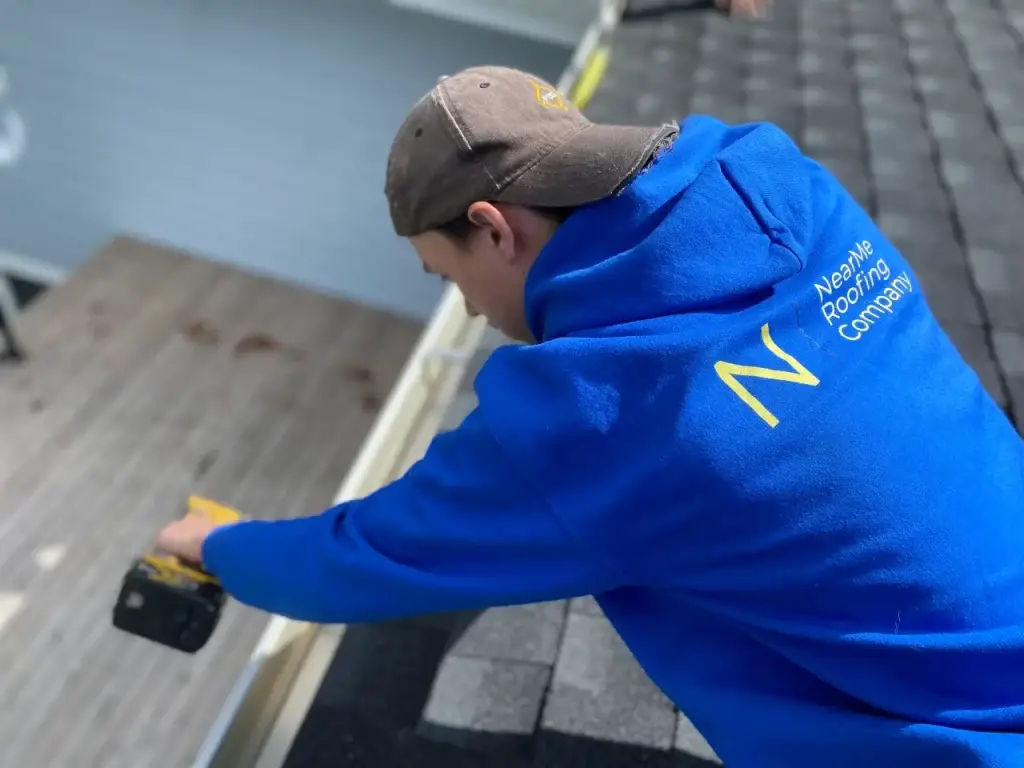a roofing expert cleaning a window and perfoming roof maintenanc