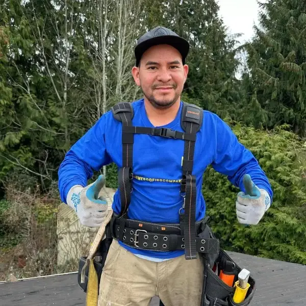 man wearing a blue jacket and standing on a roof