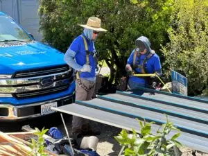 a group of roofing experts wearing blue shirts and hats