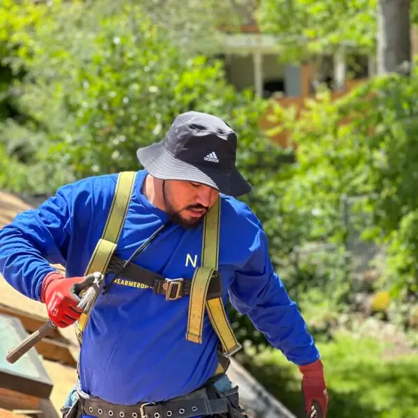 man wearing a blue shirt installing a new roof