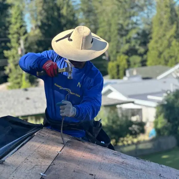 man with a hat working on a roof