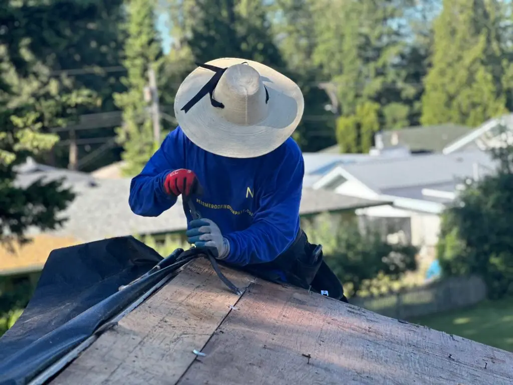 roofer on a ladder fixing a roof