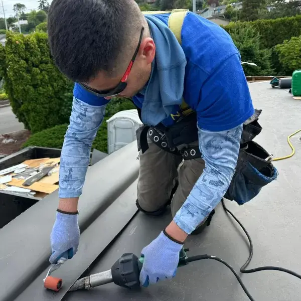 man in a blue shirt installing a roof