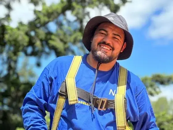 a man wearing a blue construction jacket smiling