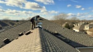 a person standing on a roof to install a roof ventilation system