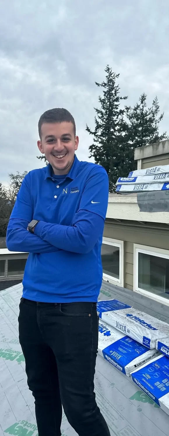expert male roofer with folded arms standing on the roof
