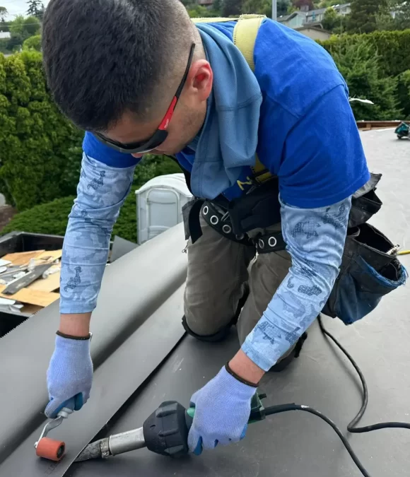 man in a blue shirt installing a roof