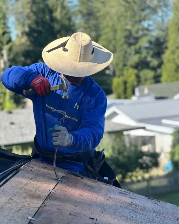man with a hat working on a roof
